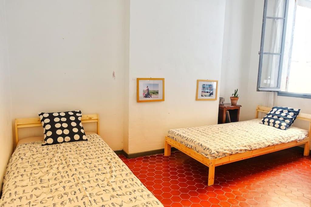 a bedroom with two beds and a window at Tout le charme de l&#39;ancien marseillais in Marseille