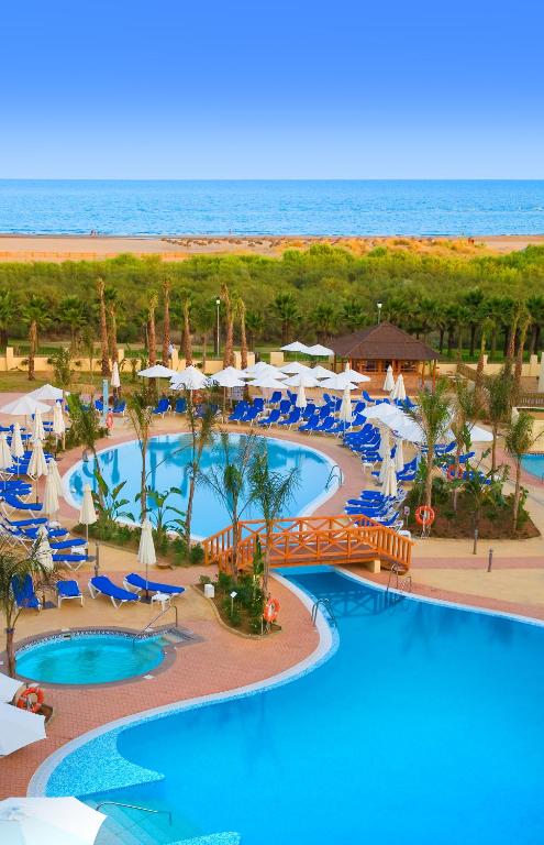 an aerial view of a resort pool with chairs and umbrellas at Playamarina in Isla Canela