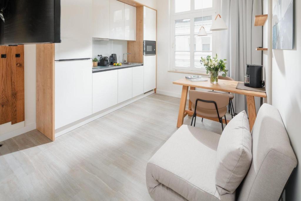 een keuken en een woonkamer met een tafel en een bank bij Nordstrandperle Ap H6 in Norderney
