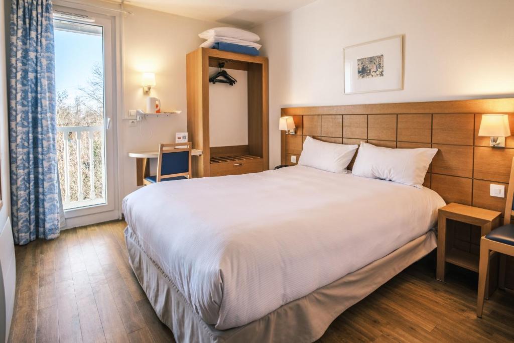 Postel nebo postele na pokoji v ubytování Hotel Strasbourg - Montagne Verte & Restaurant Louisiane