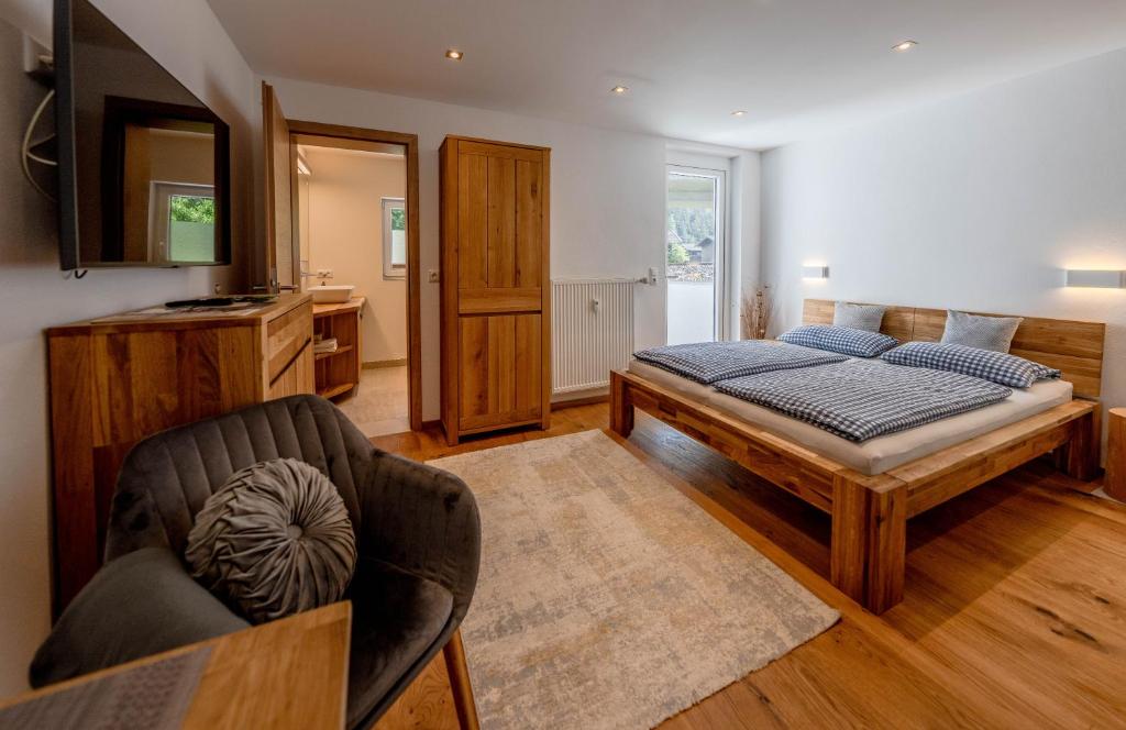 1 dormitorio con 1 cama y 1 silla en Ferienwohnungen Veronika Wohnung 1 en Mittenwald