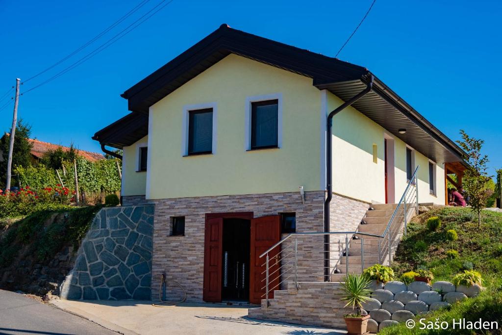 une petite maison blanche avec une porte rouge dans l'établissement Vinska klet Seršen, à Dobrovnik
