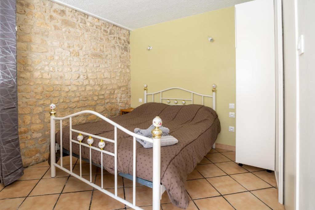een slaapkamer met een bed met een pop op een tafel bij LaConciergerieJonzac, Résidence La Barberie in Saint-Martial-de-Vitaterne
