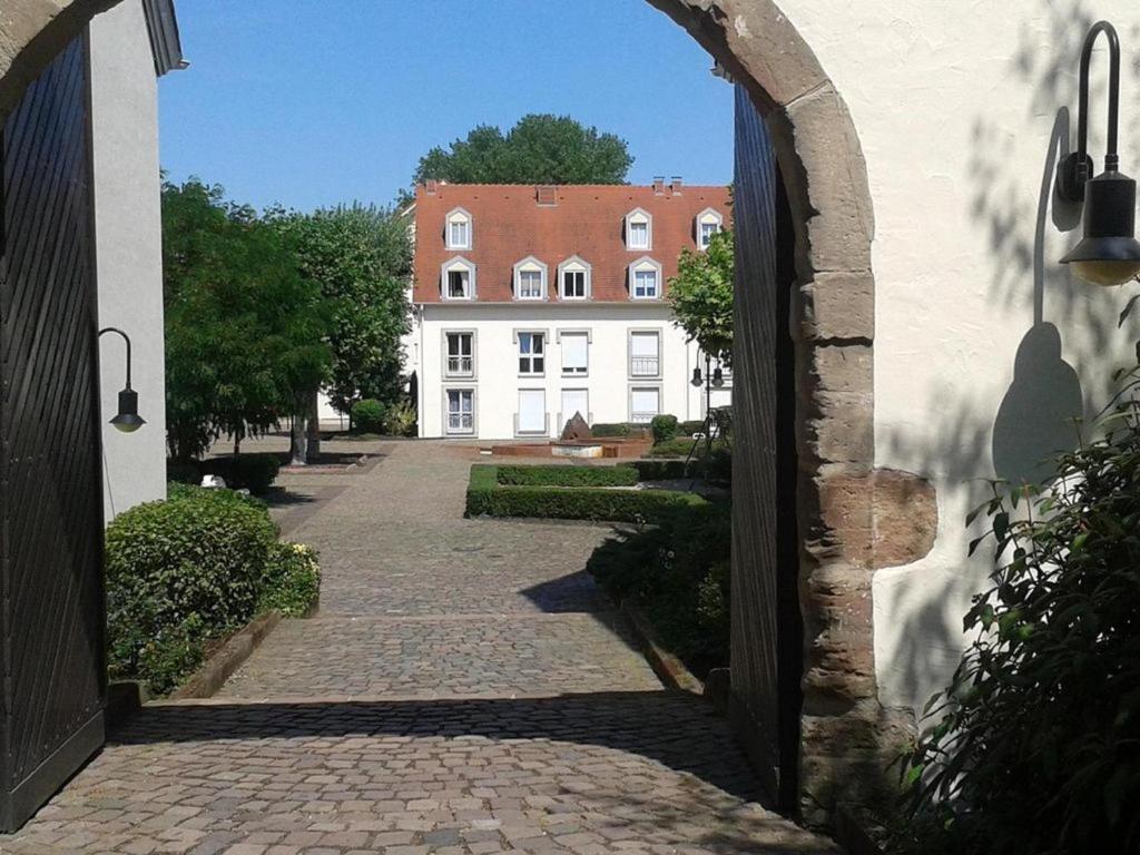 Blick auf ein Gebäude aus einem Torbogen einer Straße in der Unterkunft AMF Ferienwohnungen historischer Soutyhof in Saarlouis