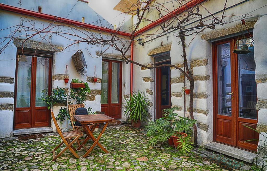 uma casa com uma mesa de madeira em frente em La Corte di Grazia_IUN P2039/40 em Nuoro