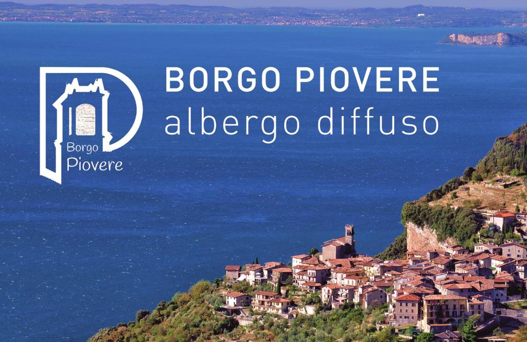 Blick auf eine Stadt auf einem Hügel neben dem Meer in der Unterkunft Albergo Diffuso Borgo Piovere in Tignale in Tignale