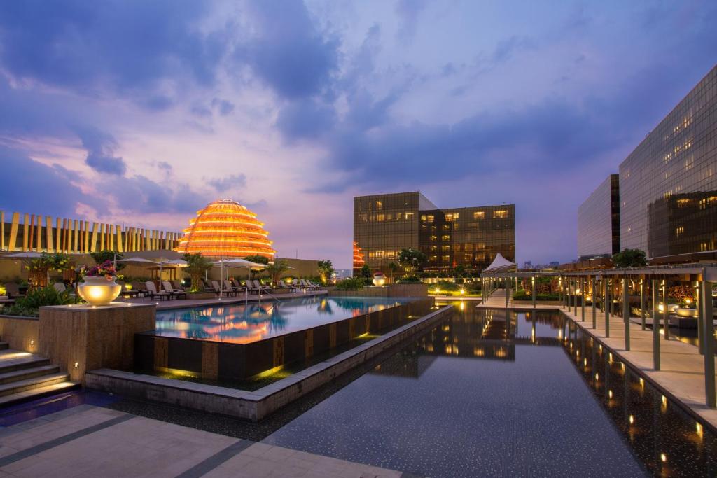 una gran piscina en una ciudad por la noche en City of Dreams - Nobu Hotel Manila, en Manila