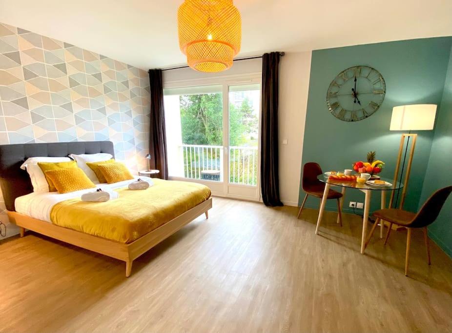ein Schlafzimmer mit einem Bett und einer Uhr an der Wand in der Unterkunft Pluton - SILS in Caen