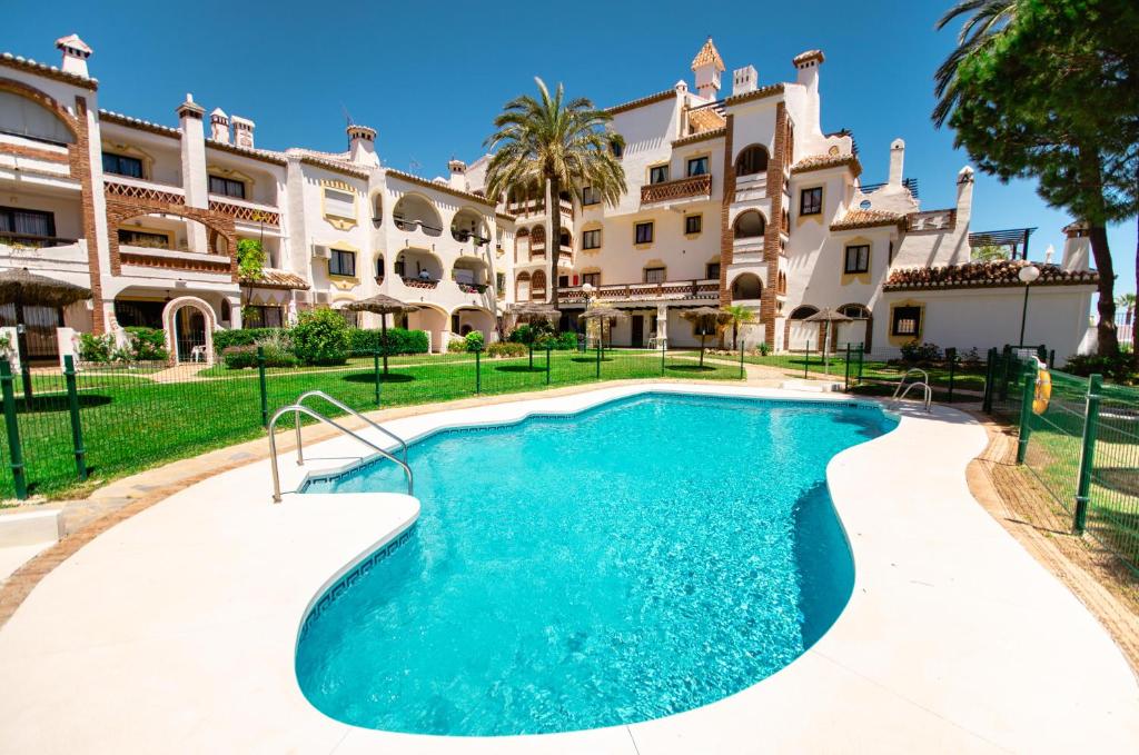 a swimming pool in front of a building at Calahonda apartments - Los Jarales in Mijas Costa