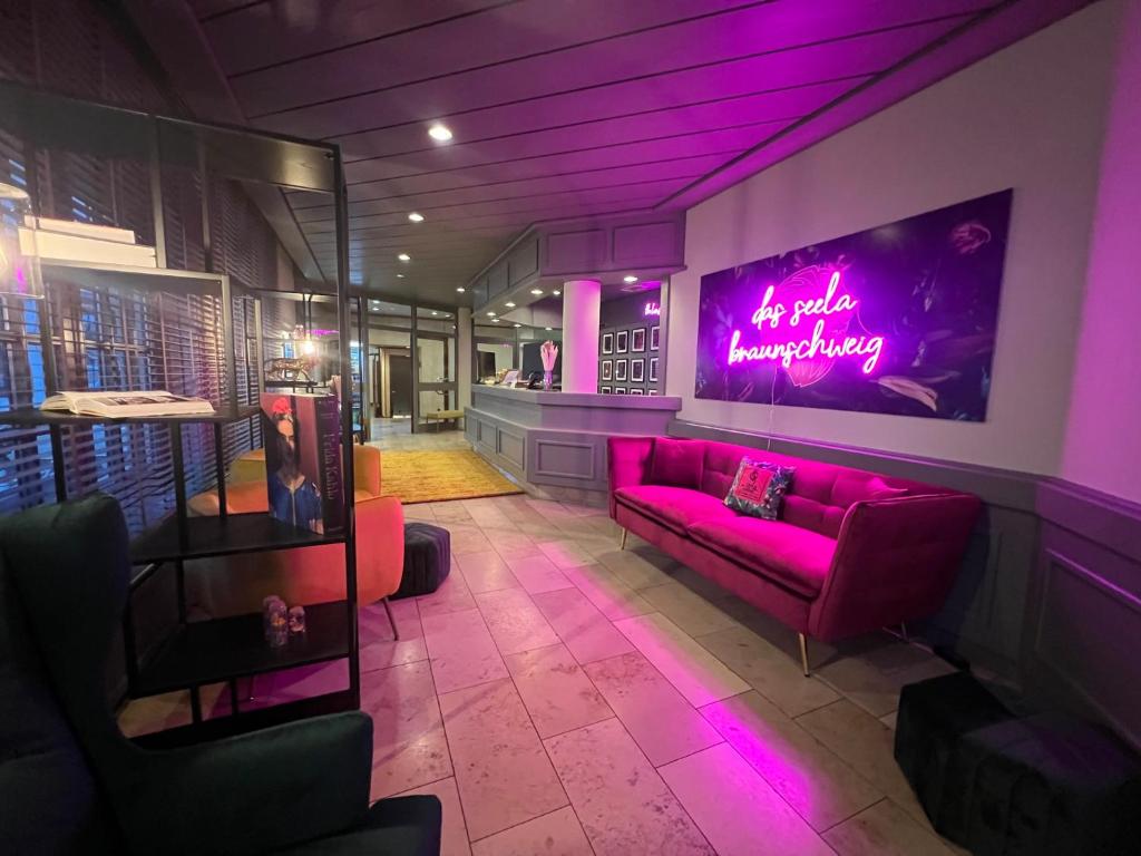 a living room with purple lighting and a couch at Das Seela Braunschweig in Braunschweig