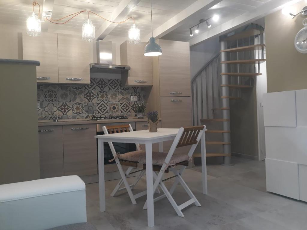 a kitchen with a table and chairs in a room at Antico-Vicolo Appartamento Viviana in Vercelli