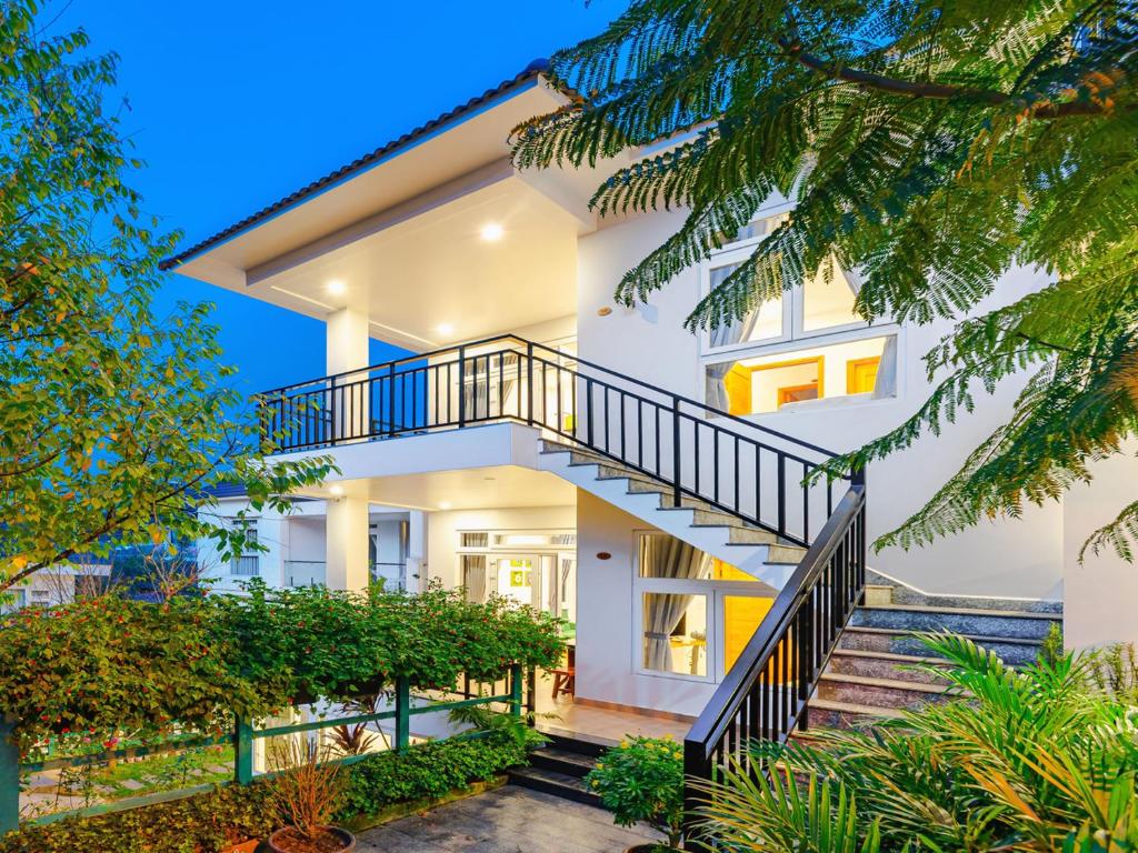 a white house with stairs in front of it at Lavini House in Da Lat