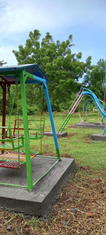 un gruppo di altalene e scivoli in un parco di Selong Belanak Bungalows a Selong Belanak