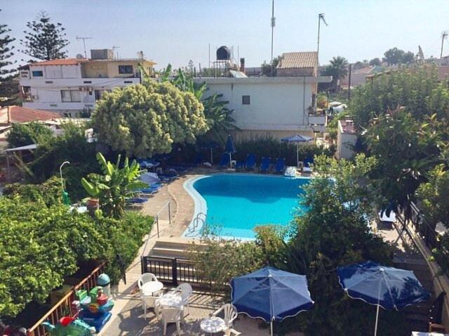 una vista sul tetto di una piscina con ombrelloni di ROMANTZA apartments ad Agia Marina Nea Kydonias