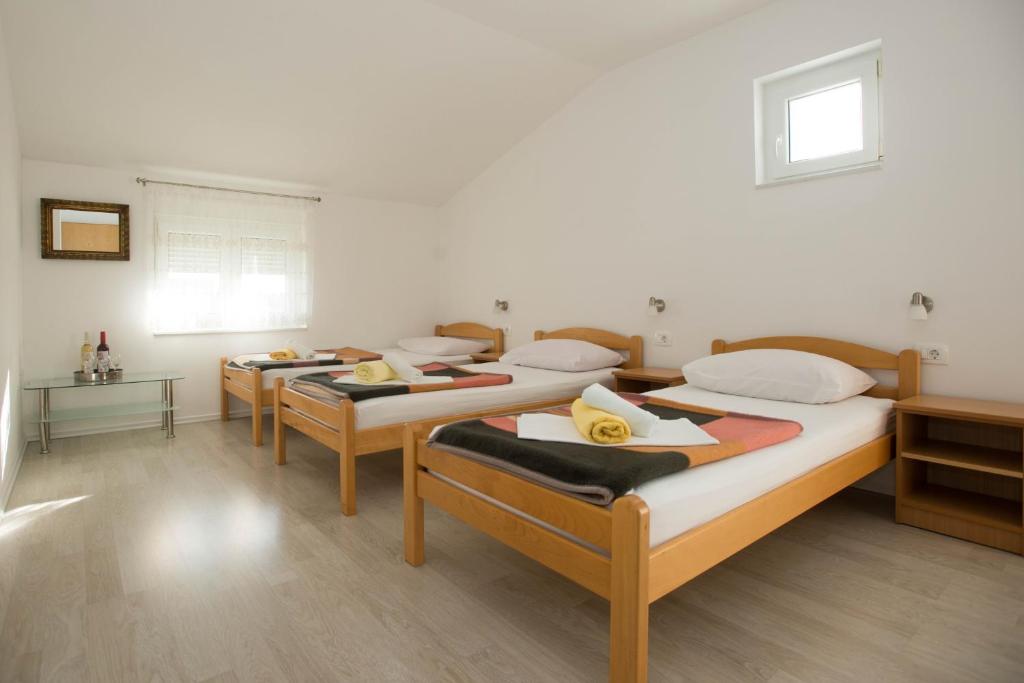a group of four beds in a room at Rooms Ivana in Međugorje