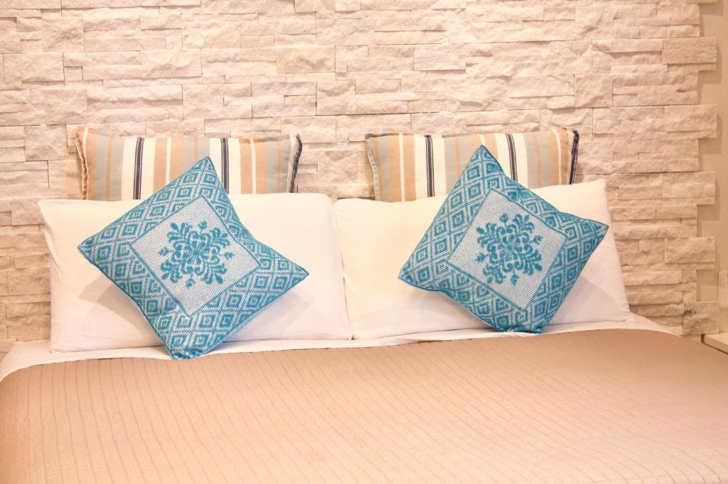 zwei blaue und weiße Kissen auf dem Bett in der Unterkunft La Casetta del Marinaio in Fano