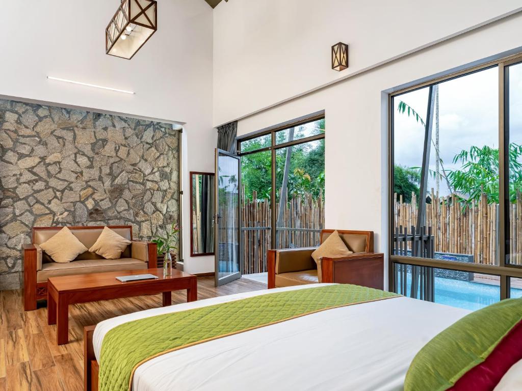 a bedroom with a bed and a view of a pool at Coffee Greens Resort in Wayanad