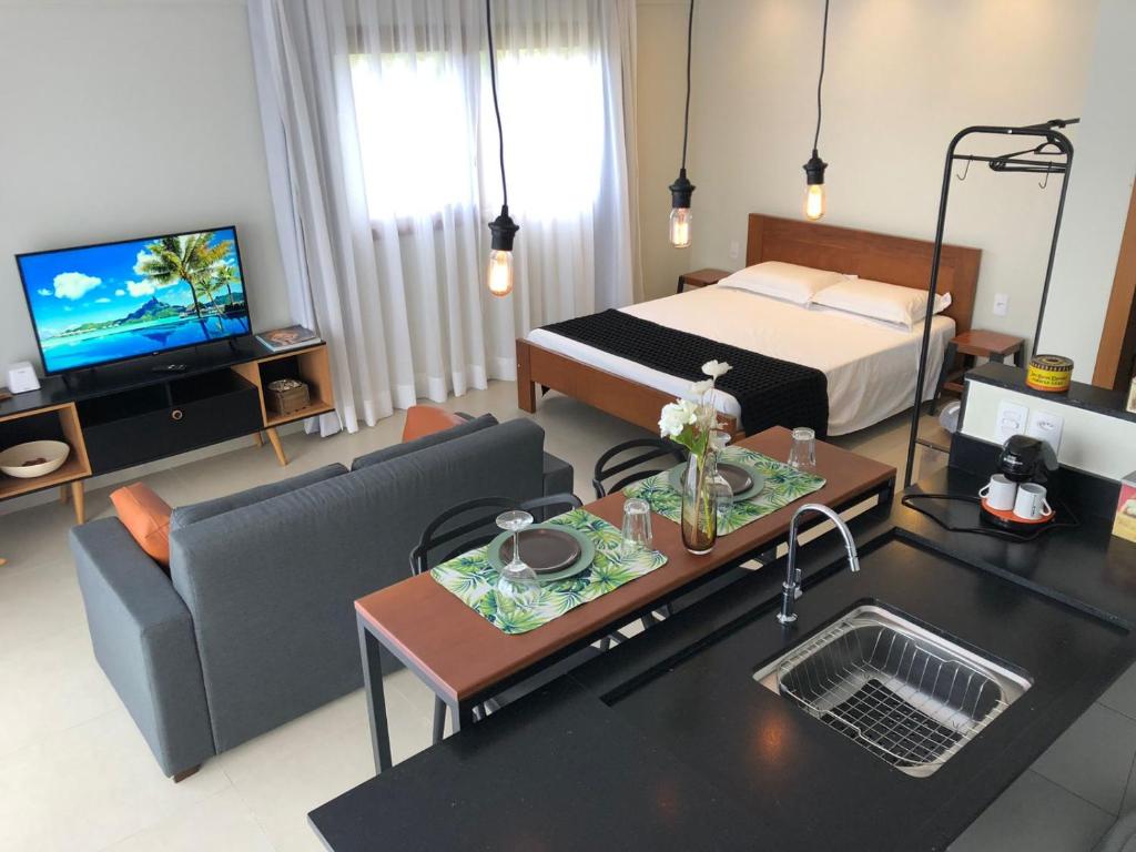 - un salon avec un lit, un canapé et une table dans l'établissement Recanto dos Ipês 1, à Domingos Martins