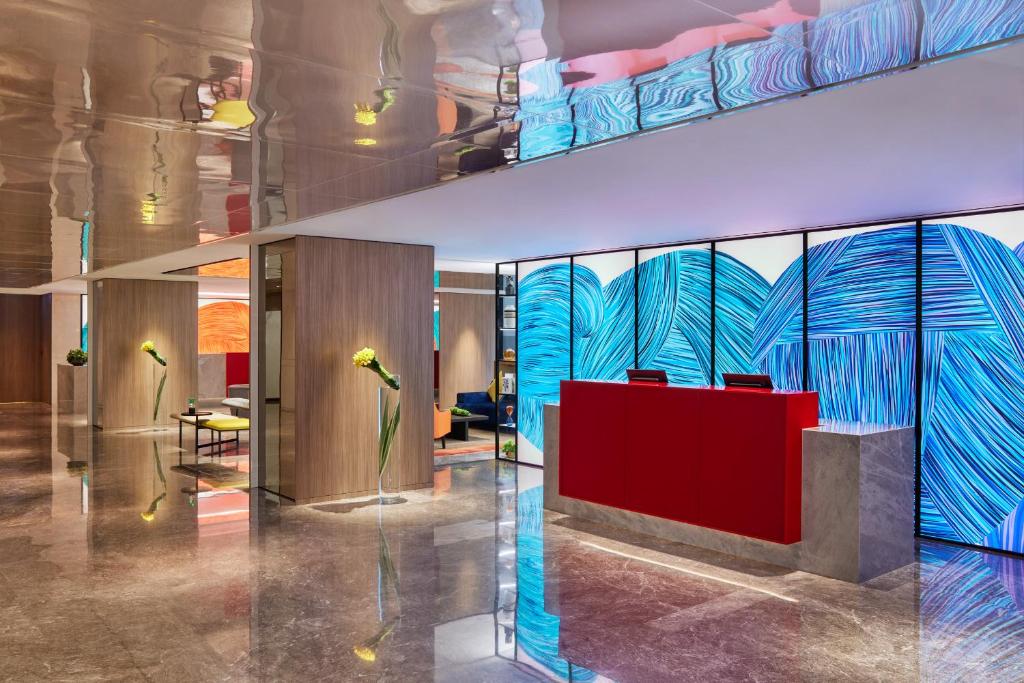 a lobby with a red counter and a blue wall at Prince Hotel, Marco Polo in Hong Kong