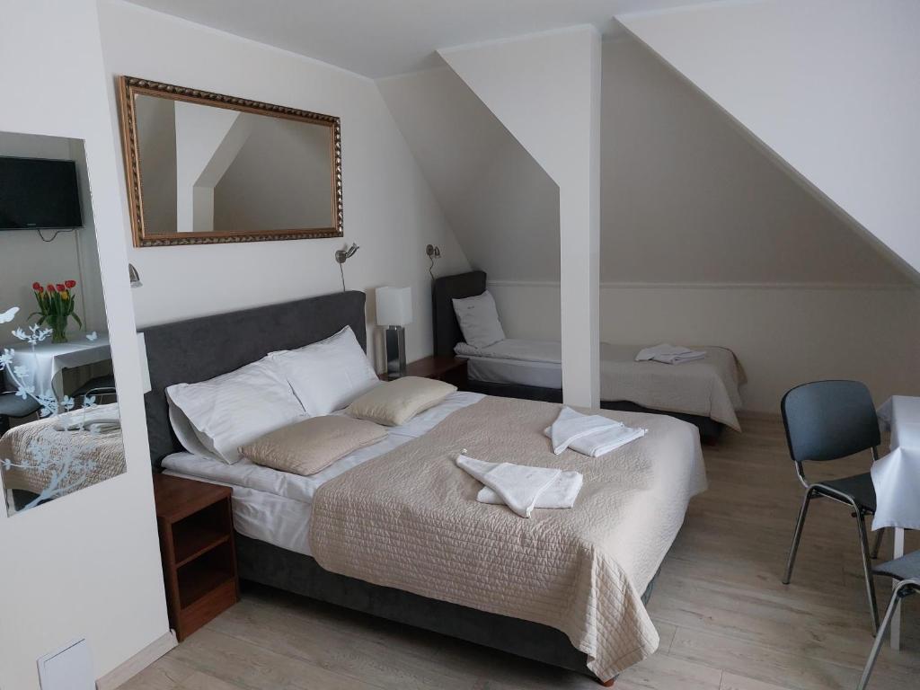1 dormitorio con 1 cama con espejo y silla en Willa Julia, en Gdynia