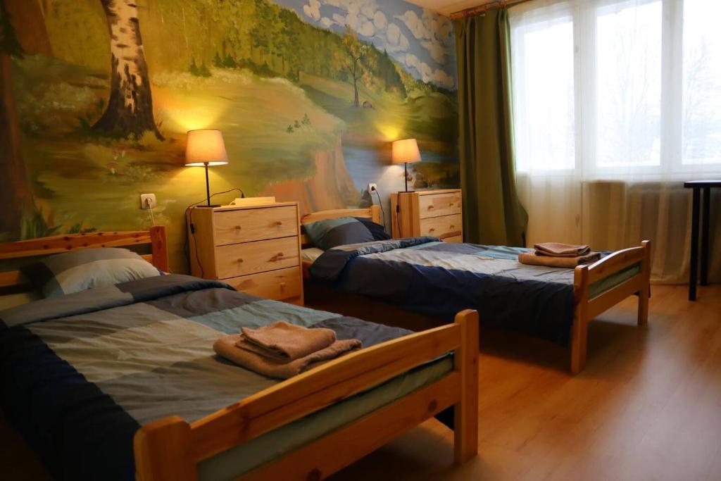 1 dormitorio con 2 camas y un cuadro en la pared en Fejas Dzīvoklis, en Vecpiebalga
