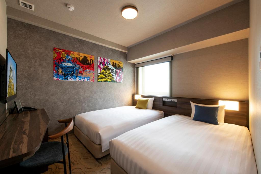 Habitación de hotel con 2 camas y ventana en Just Sleep Osaka Shinsaibashi, en Osaka