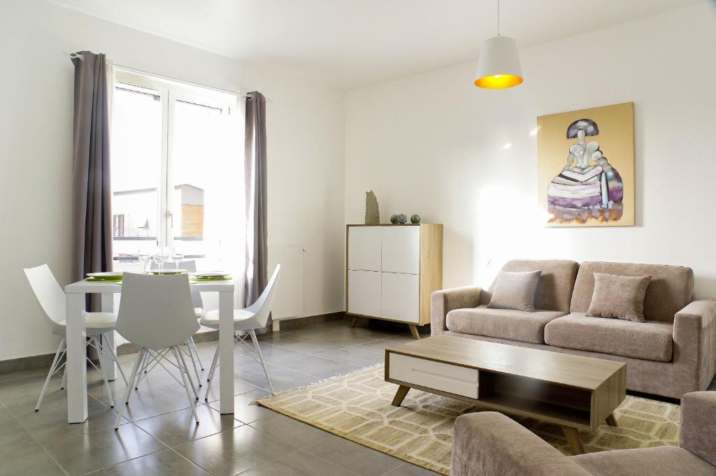 un salon avec un canapé et une table dans l'établissement Cheverus - Appartement 1 chambre avec ascenseur et Parking, à Bordeaux