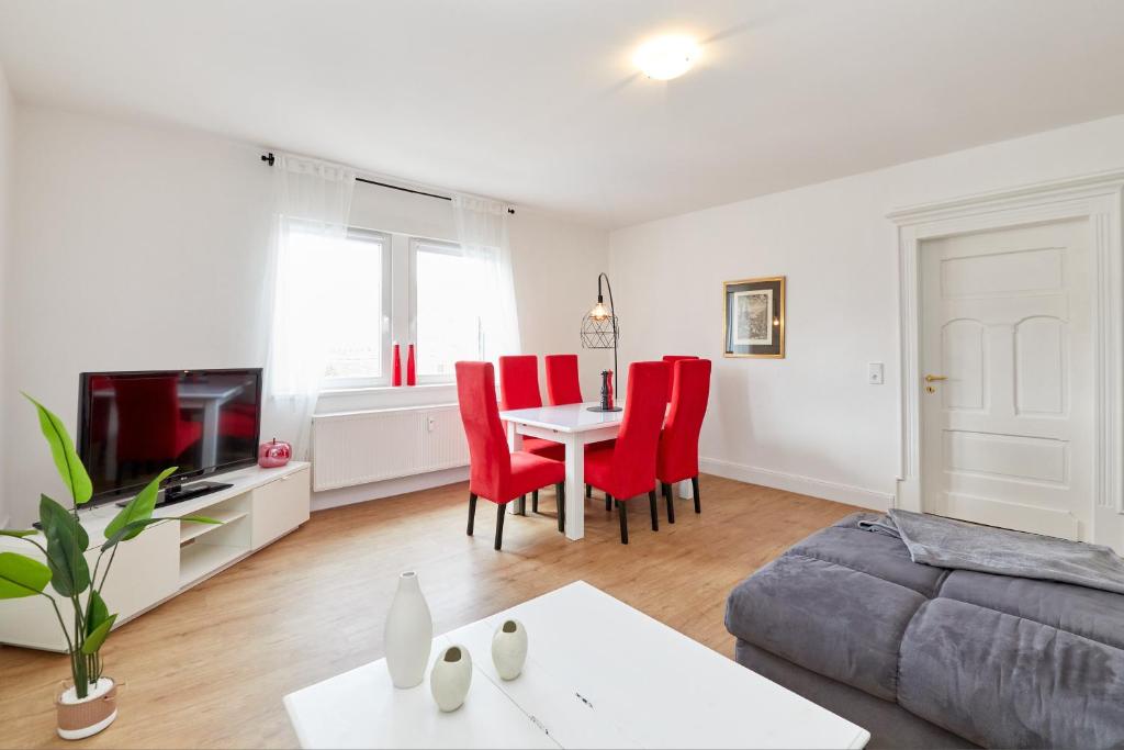 sala de estar con sofá, mesa y sillas rojas en Fewo am Gestade 1 en Bernkastel-Kues