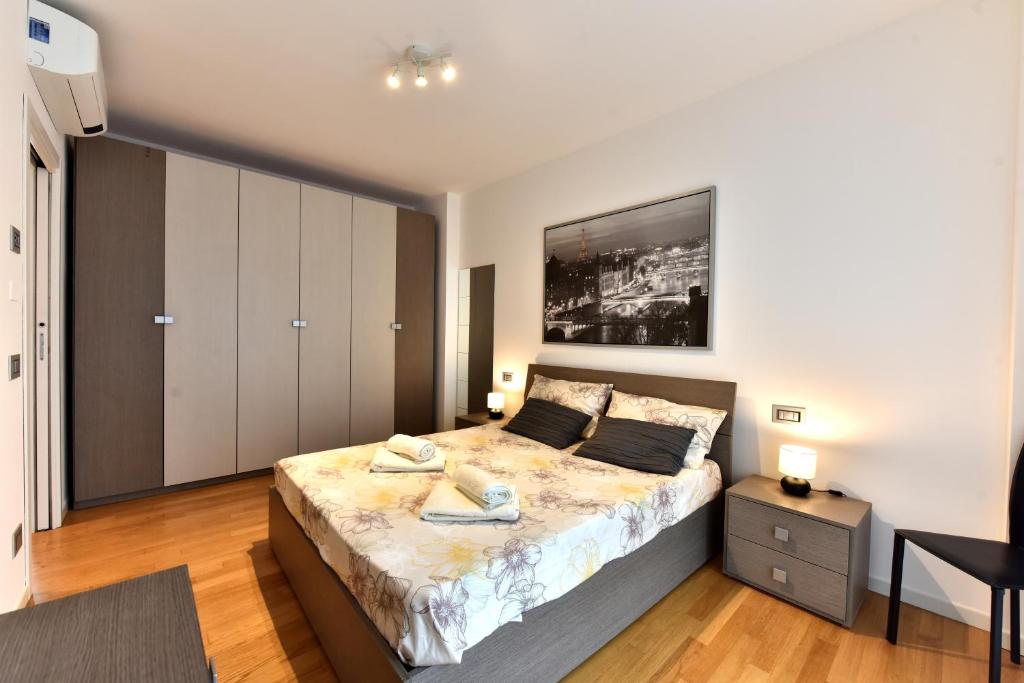una camera con un grande letto di CaseOspitali - Casa Kikka elegante appartamento con balcone in nuovo condominio a Cernusco sul Naviglio