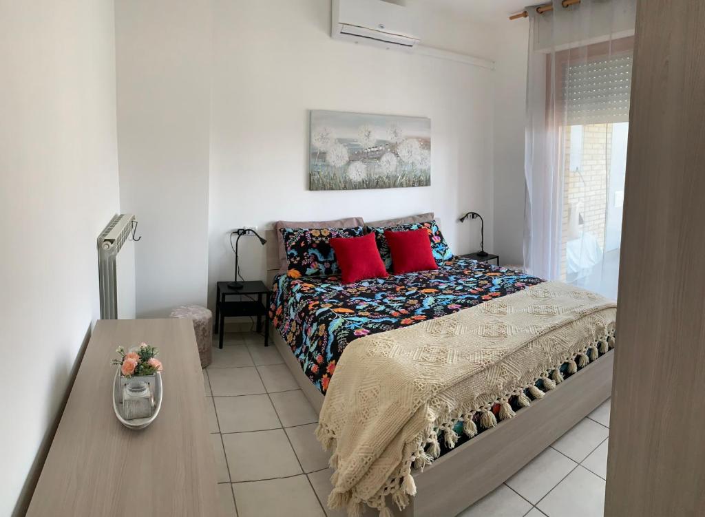 een slaapkamer met een bed met rode kussens en een tafel bij Casa Silvia in Pescara