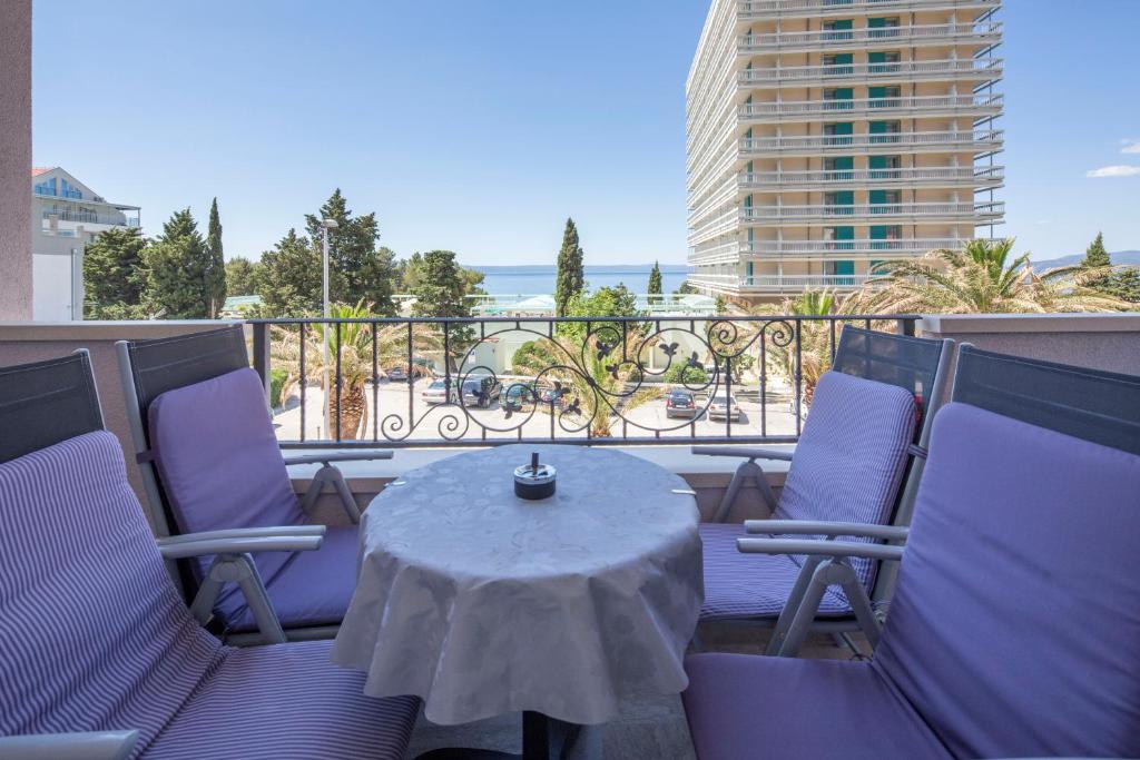 eine Terrasse mit einem Tisch und Stühlen auf dem Balkon in der Unterkunft Villa Nena in Makarska