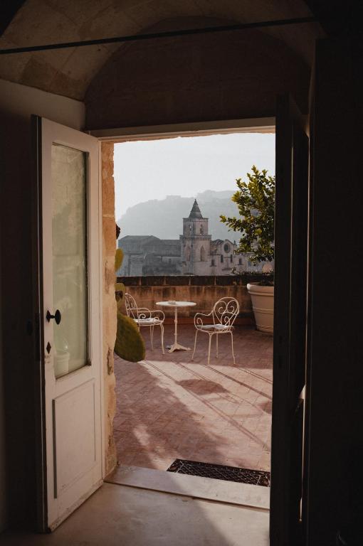 an open door to a patio with a table and chairs at Sant&#39;Angelo, Matera - Small Luxury Hotels in Matera