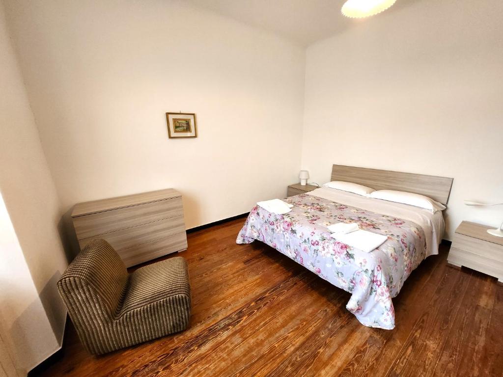 ein Schlafzimmer mit einem Bett und einem Stuhl darin in der Unterkunft Raggio di sole in Levanto