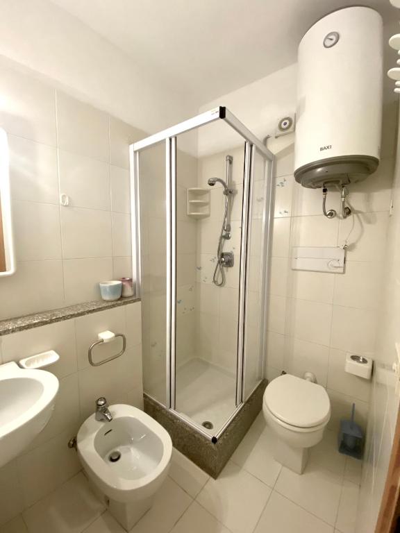 a bathroom with a shower and a toilet and a sink at Residence Porto Coda Cavallo in San Teodoro