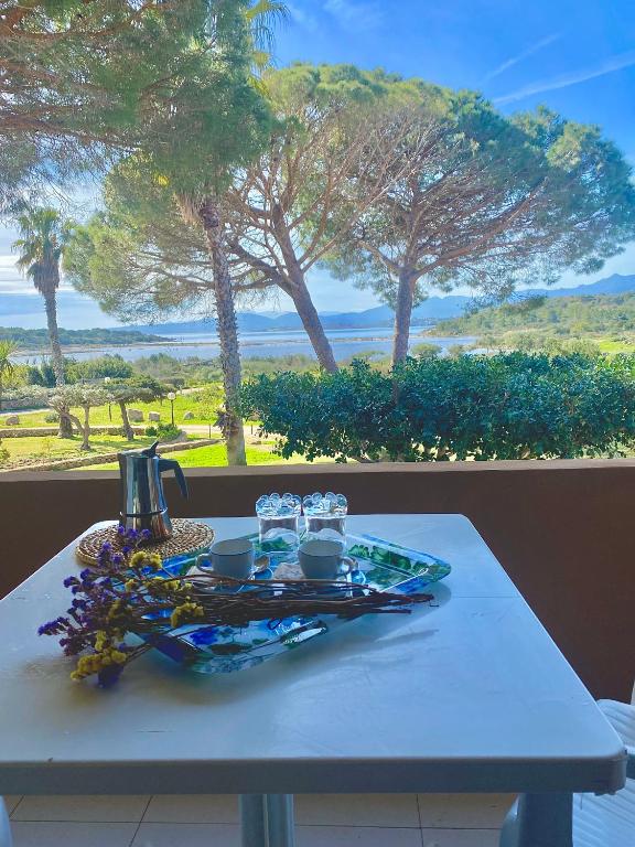 a table with a plate of food and glasses on it at Residence Porto Coda Cavallo in San Teodoro
