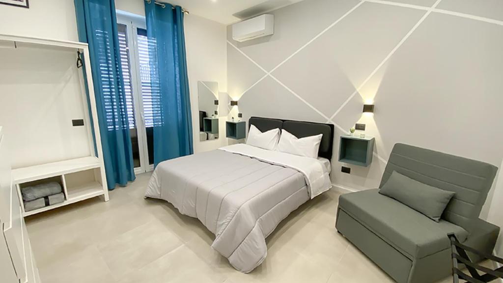 a white bedroom with a bed and a chair at Palermo Central in Palermo