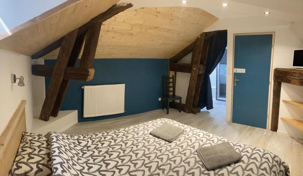1 dormitorio con 1 cama en una habitación con vigas de madera en Chambre avec SDB privative, cuisine et salon partagés, 
