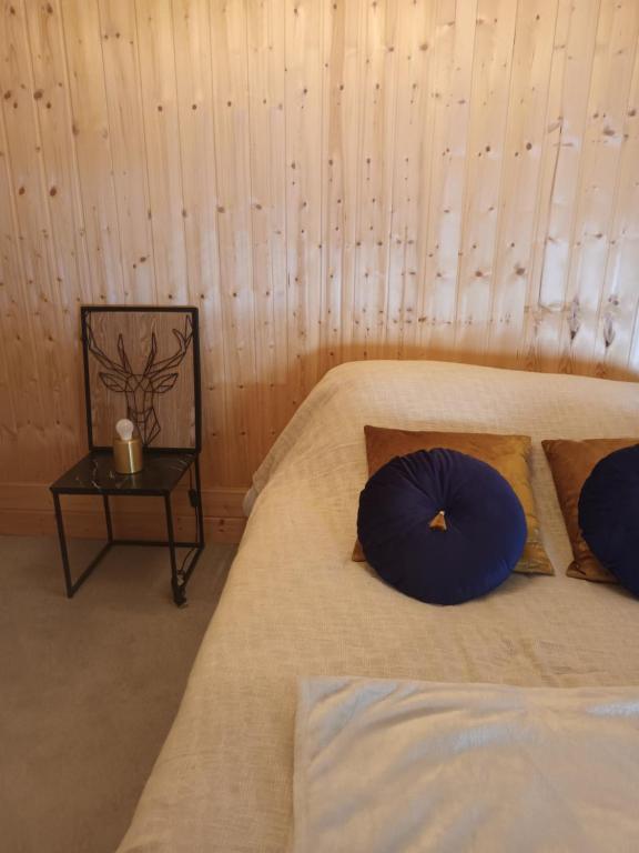 a bedroom with two beds with blue pillows and a table at Maisonnette au cœur des Angles in Les Angles