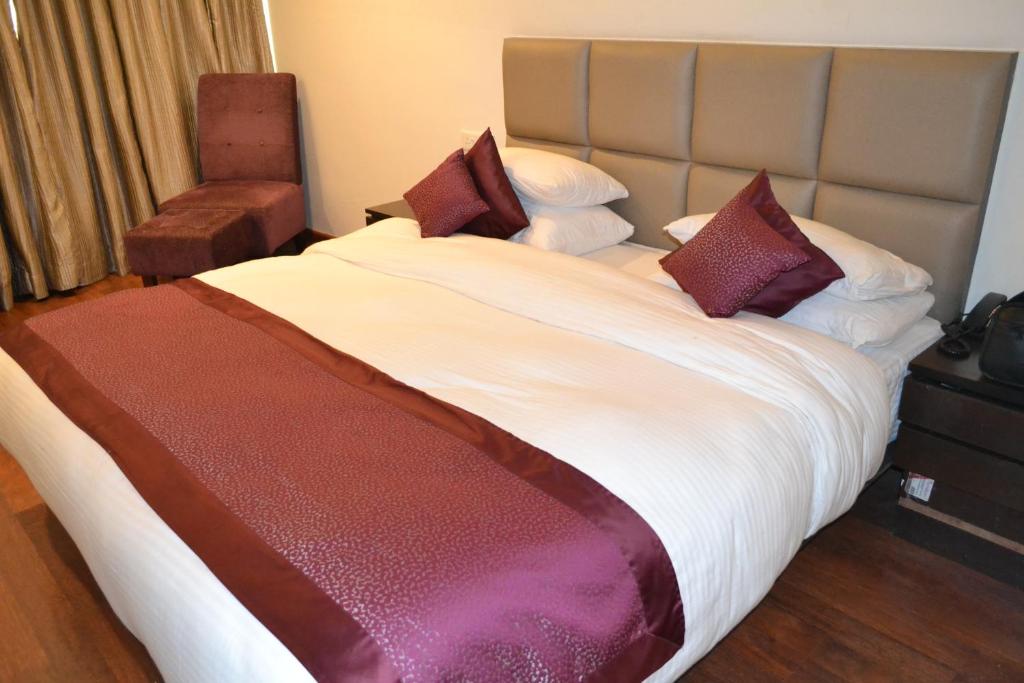 ein Schlafzimmer mit einem großen Bett mit Kissen in der Unterkunft Sobti Continental Bareilly in Bareilly