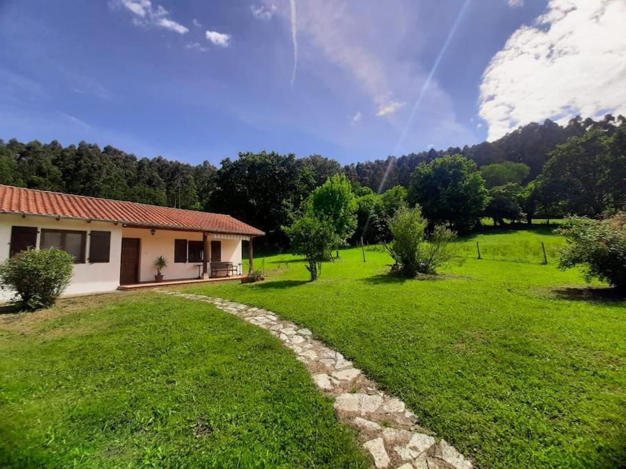 una casa en un campo verde con un camino de piedra en La Rotiza en La Collada