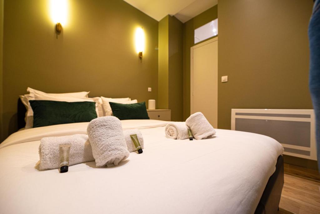 - une chambre avec un grand lit blanc et des serviettes dans l'établissement Cosy studio on bastille, à Paris