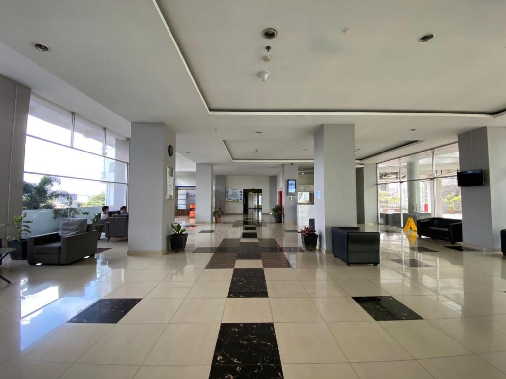 un vestíbulo vacío de un edificio de oficinas con suelo a cuadros en Easton Park Residence Jatinangor - GIANDARA, en Sayang
