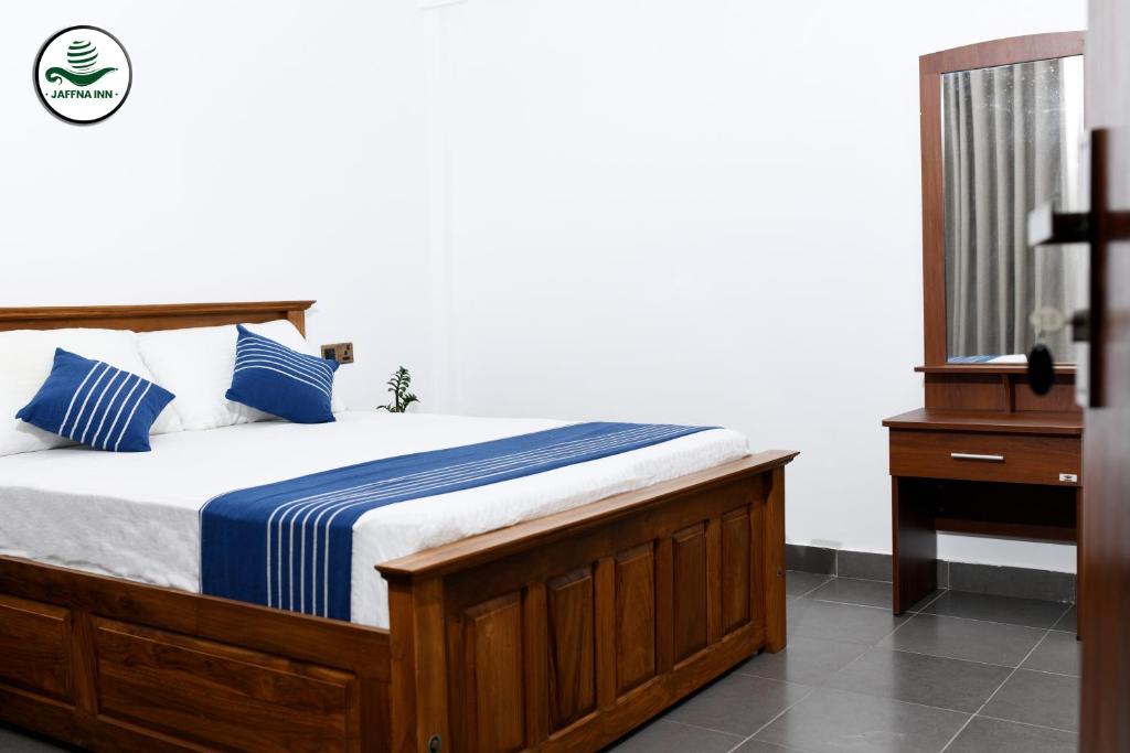 1 dormitorio con 1 cama con sábanas azules y blancas en Jaffna Inn, en Jaffna