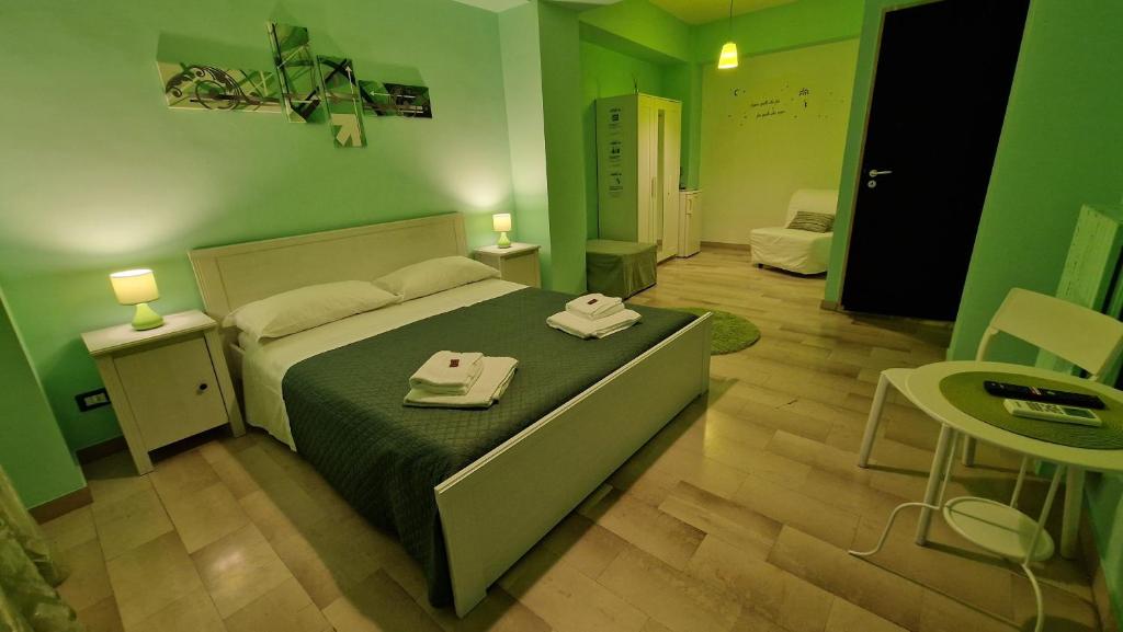 a green bedroom with a bed with two towels on it at Bari Vecchia Dimora in Bari