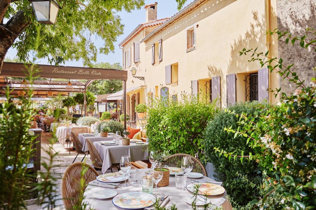 jadalnia na świeżym powietrzu ze stołami i krzesłami w obiekcie Hôtel de Charme Bello Visto w mieście Gassin
