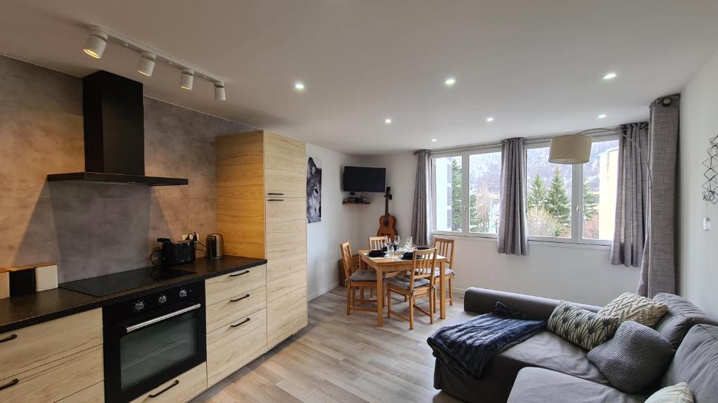 Una cocina y una sala de estar con un sofá y una mesa. en Serre Chevalier, Superbe appartement 5/7 couchages, en Saint-Chaffrey