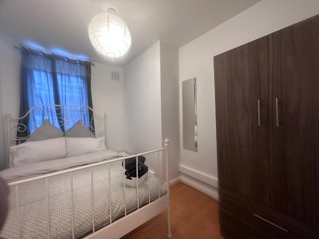 a bedroom with a crib and a large window at Holybush Bethnal Green in London