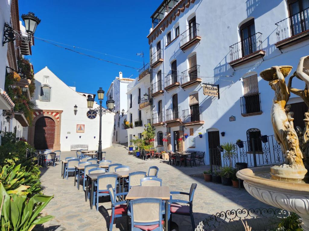 uma rua com mesas e cadeiras em frente aos edifícios em Posada La Plaza em Canillas de Albaida