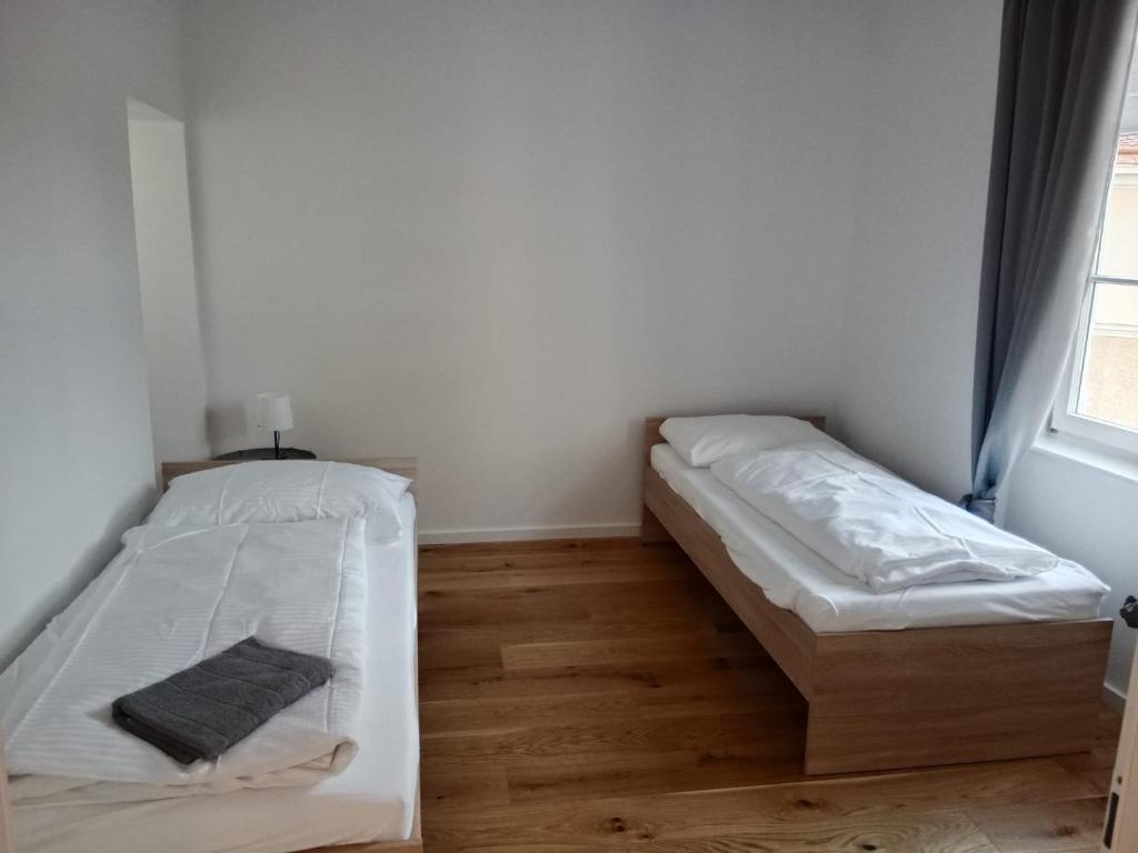 1 dormitorio con 2 camas y ventana en Krems am Campus, en Krems an der Donau