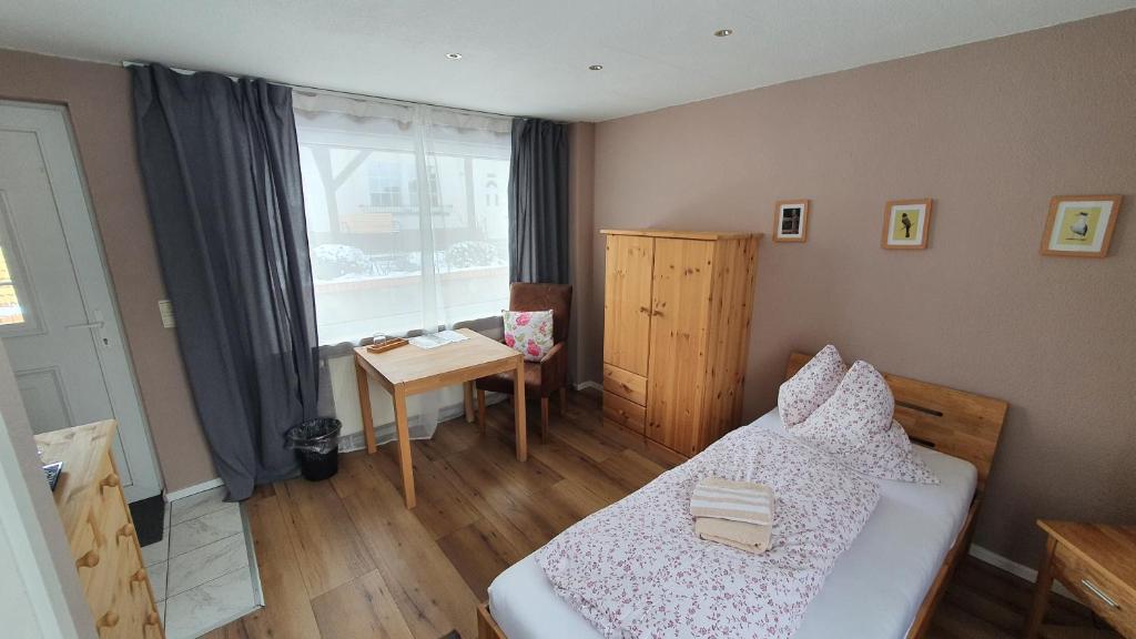 een slaapkamer met een bed, een bureau en een raam bij Pension am Silberberg in Gartz an der Oder